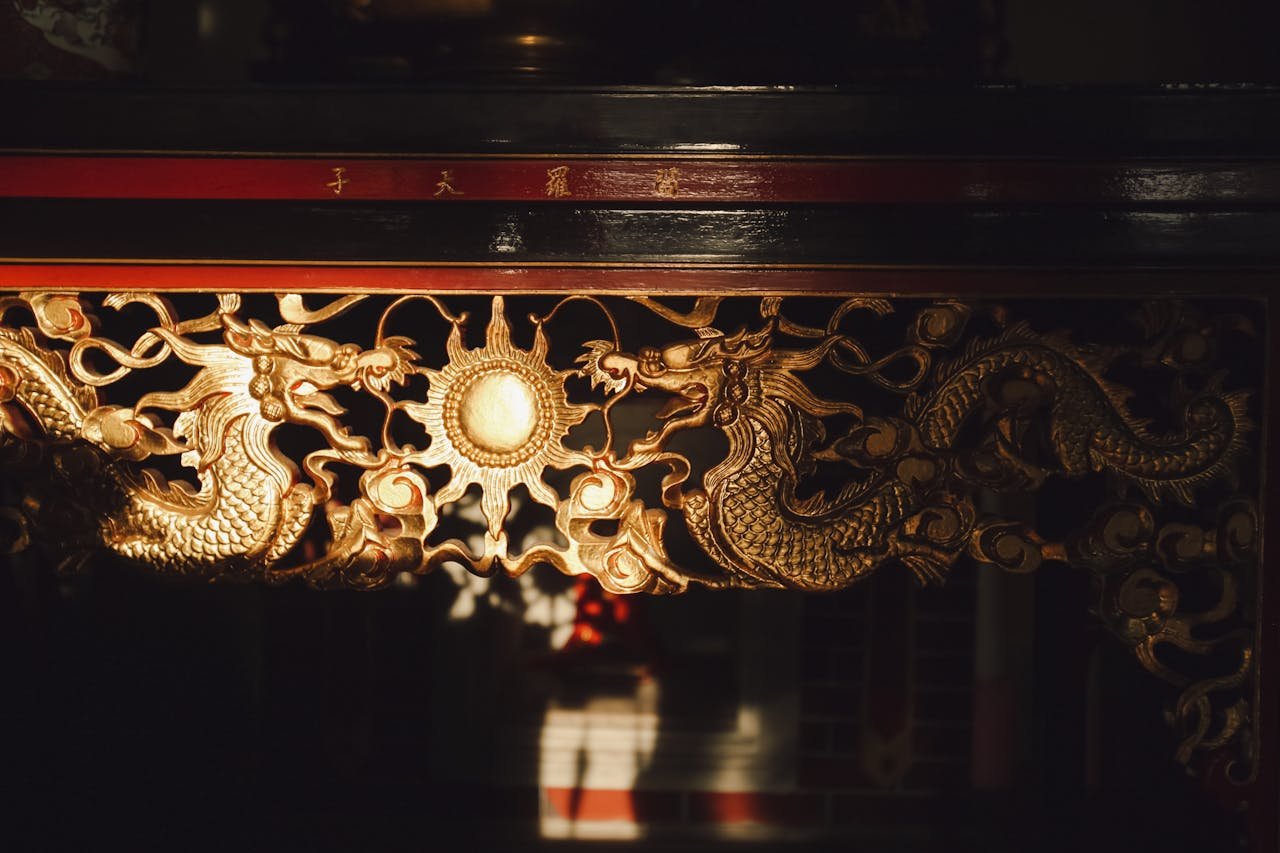 Close-up of ornate golden dragon carving in Malaysian temple decor.