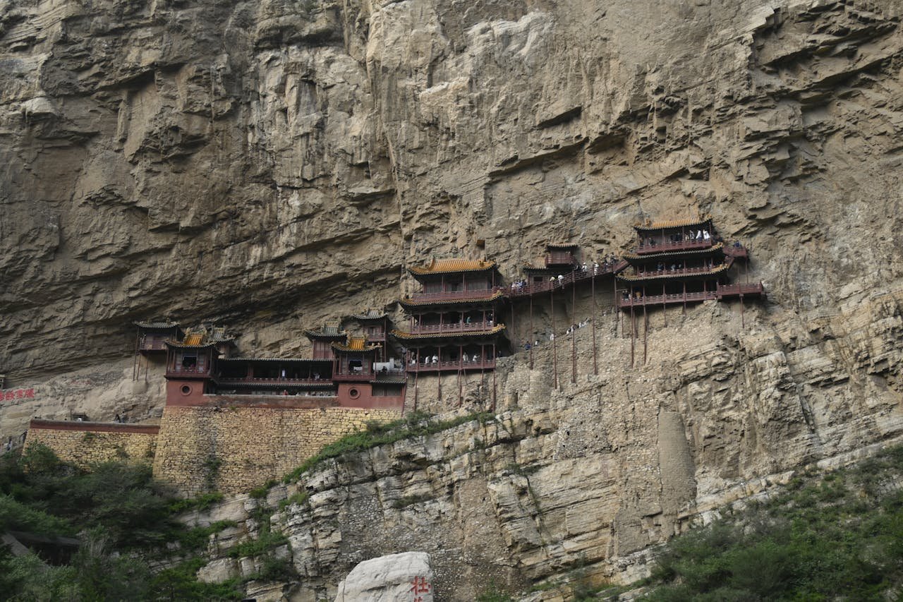 Stunning view of Chinas Hanging Monastery perched on a cliff. Ancient architecture and natural rock formations.